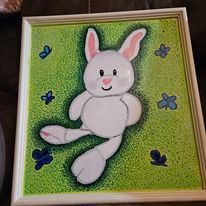 A painting of a white bunny rabbit sitting in the grass with butterflies.