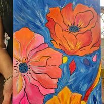 A woman is holding a painting of flowers on a blue background.