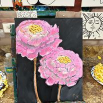 A painting of two pink flowers on a black background on a table.