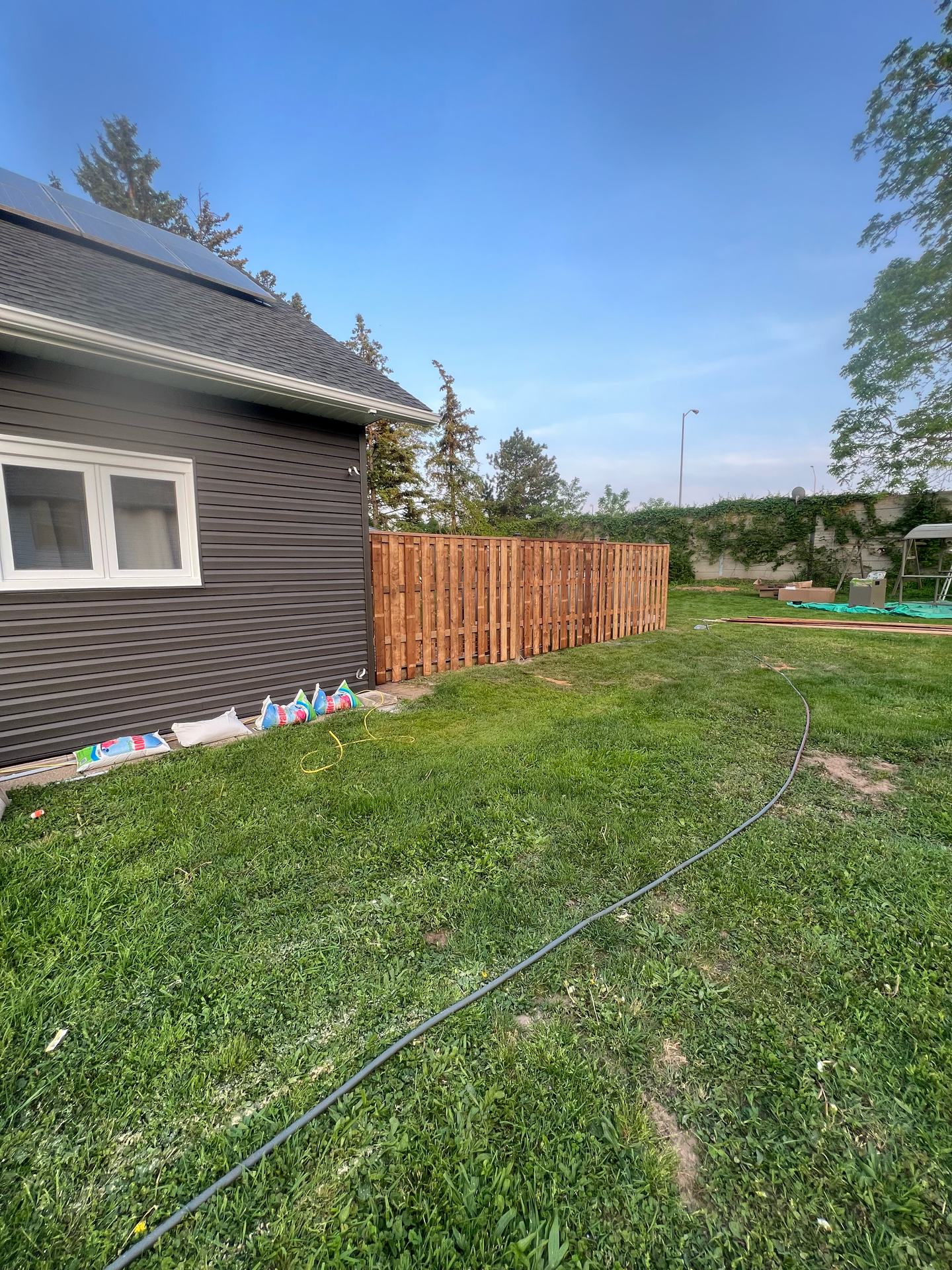 There is a wooden fence in the backyard of a house.
