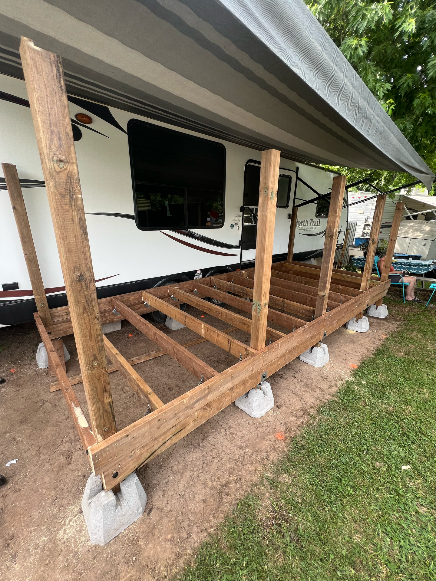 A wooden deck is being built next to a rv.