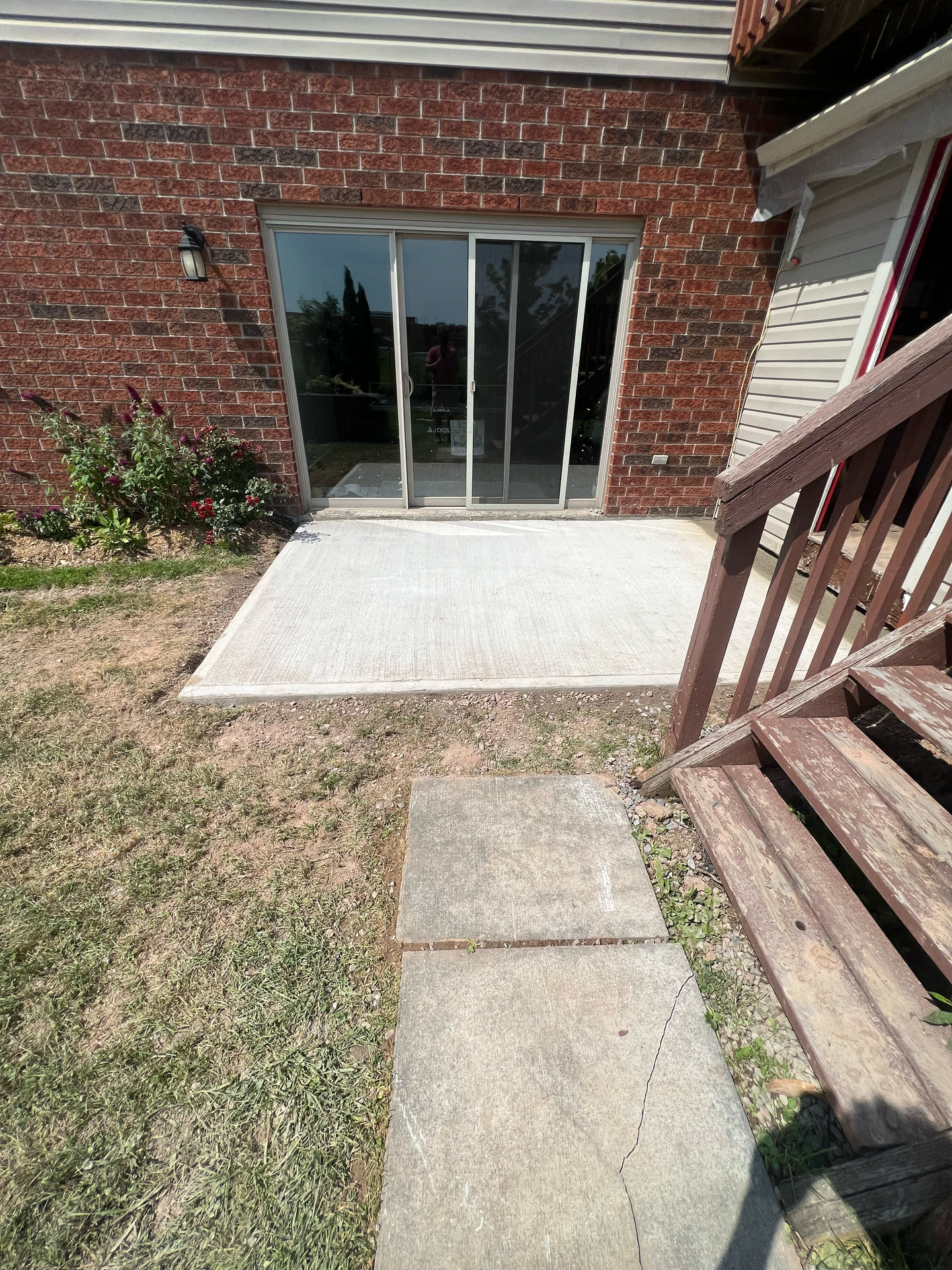 A brick house with a sliding glass door and a patio.