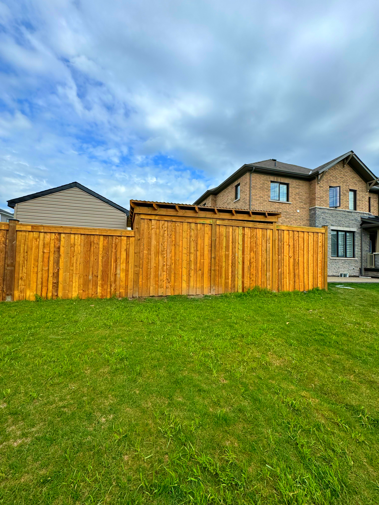 There is a wooden fence in the backyard of a house.