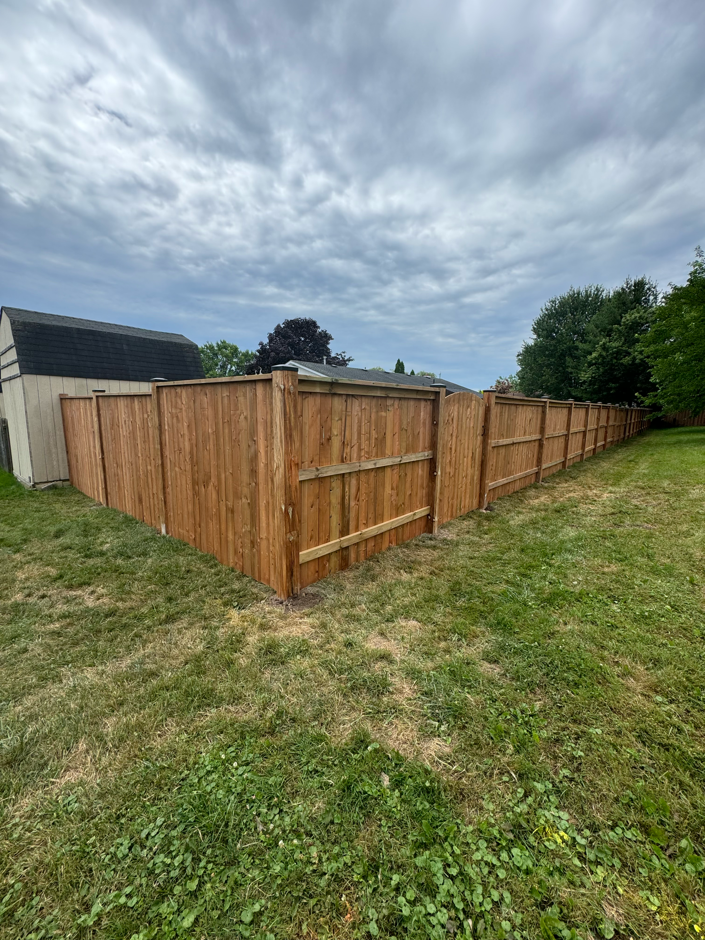 A wooden fence is sitting in the middle of a grassy field.