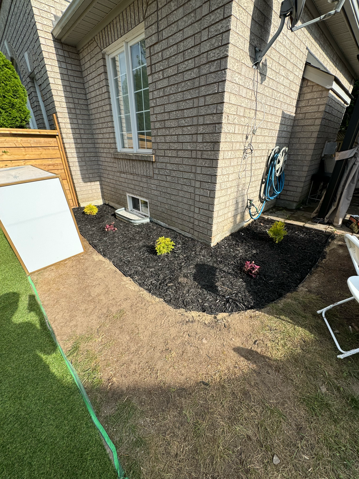 A brick house with a garden in front of it.