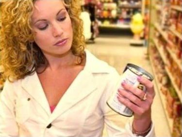 una donna con in mano un barattolo al supermercato