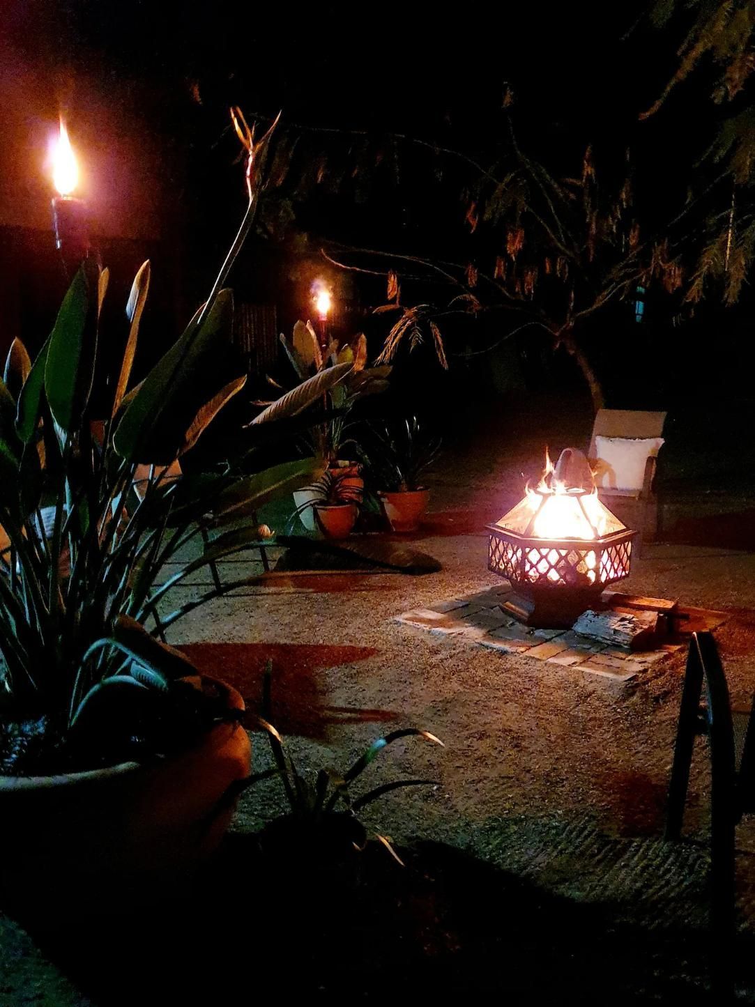 A Fire Pit Is Lit Up At Night In A Garden — Accommodation in Forbes, NSW