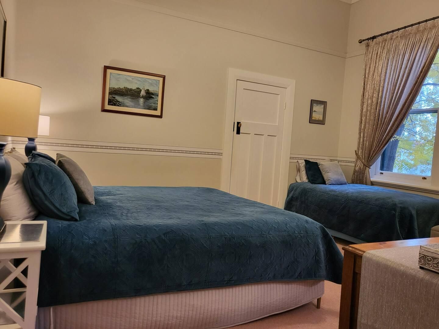 A Bedroom With Two Beds And A Painting On The Wall — Accommodation in Forbes, NSW