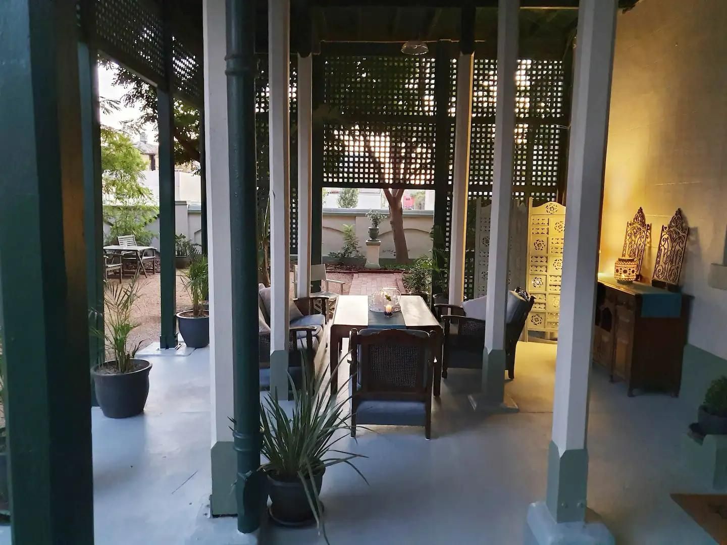 A Porch With a Table, Chairs and Potted Plants — Accommodation in Forbes, NSW