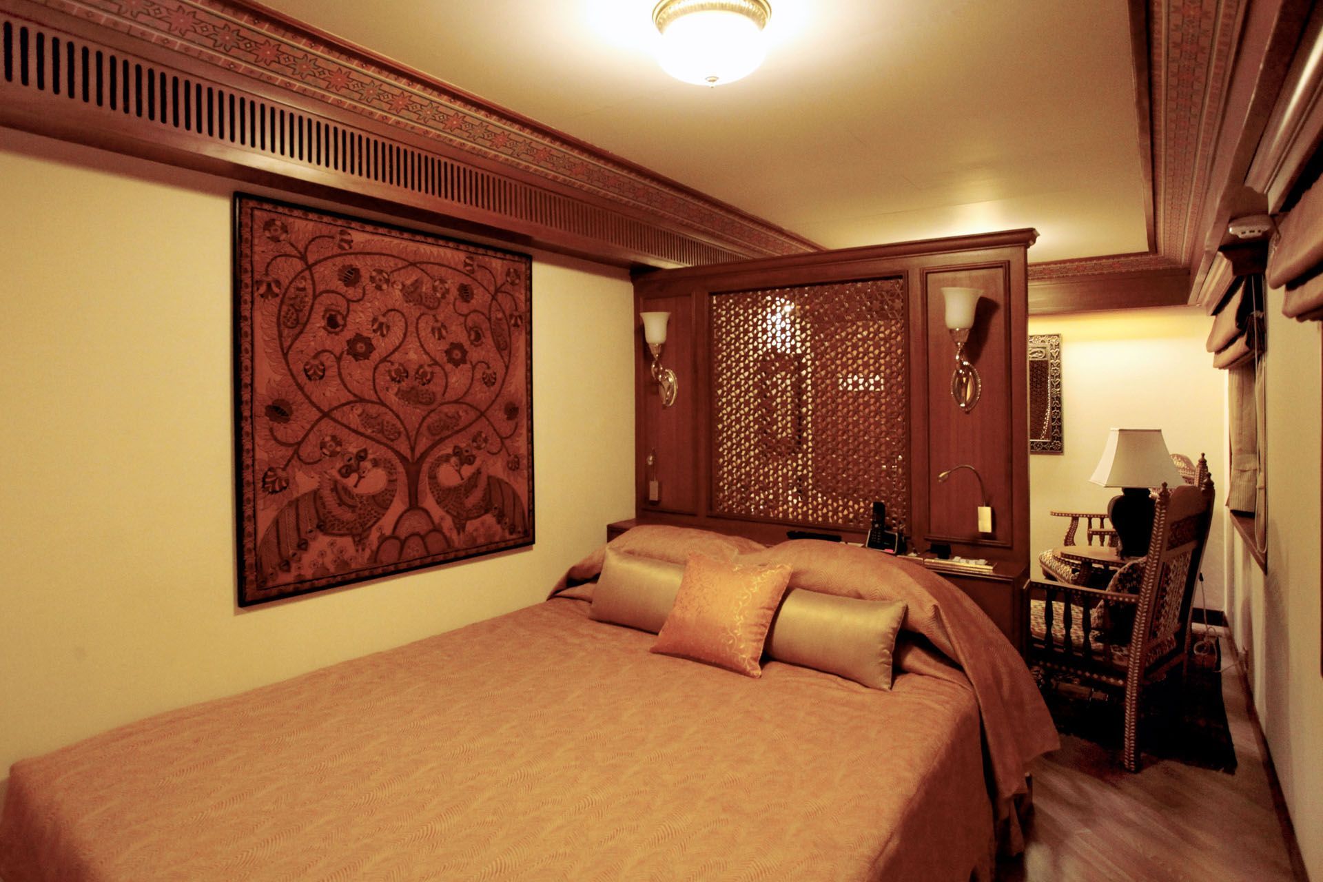 Cozy bedroom with a bed, wall tapestry, wooden cabinets, and warm lighting