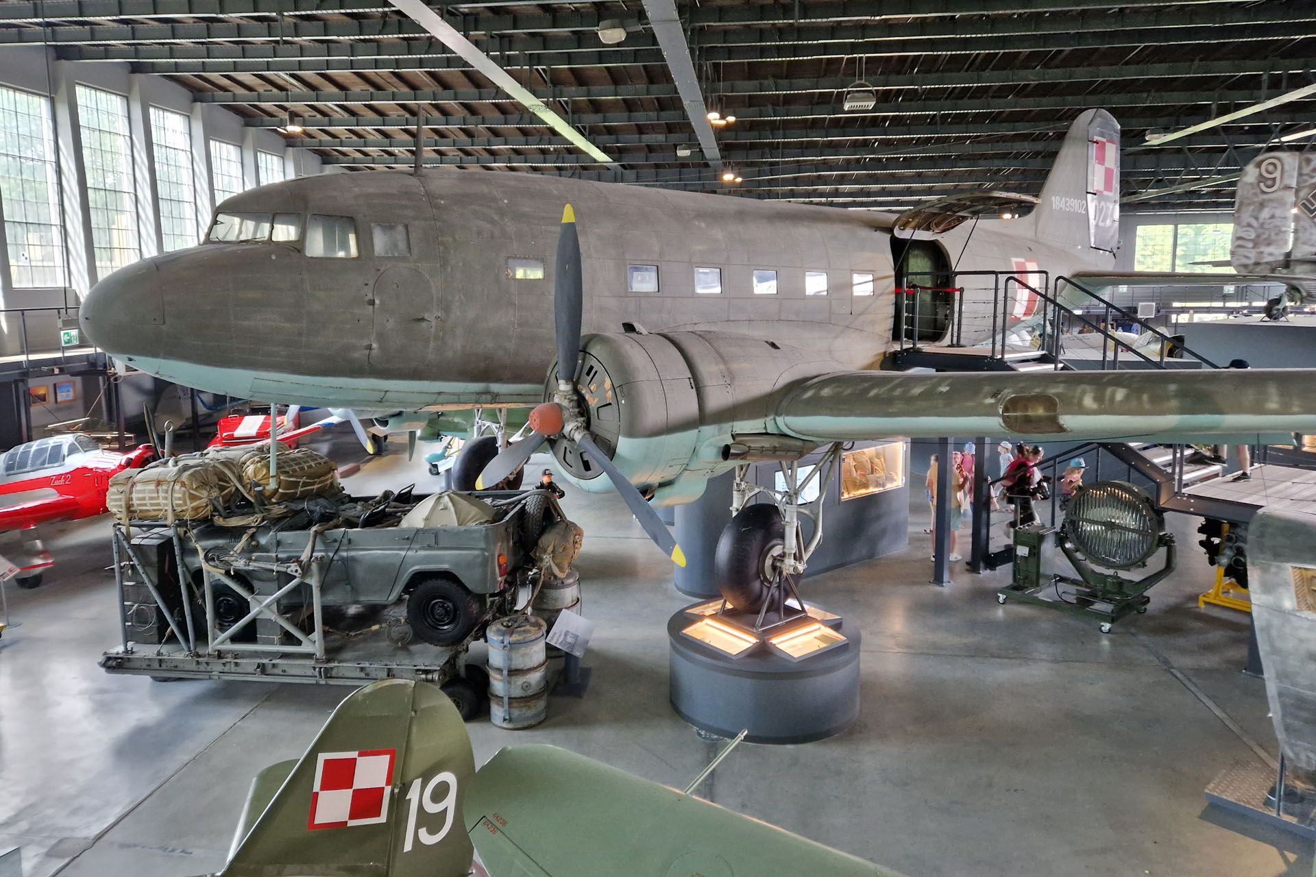 Large grey Douglas C-47 Skytrain airplane on display in a museum, with Polish markings.