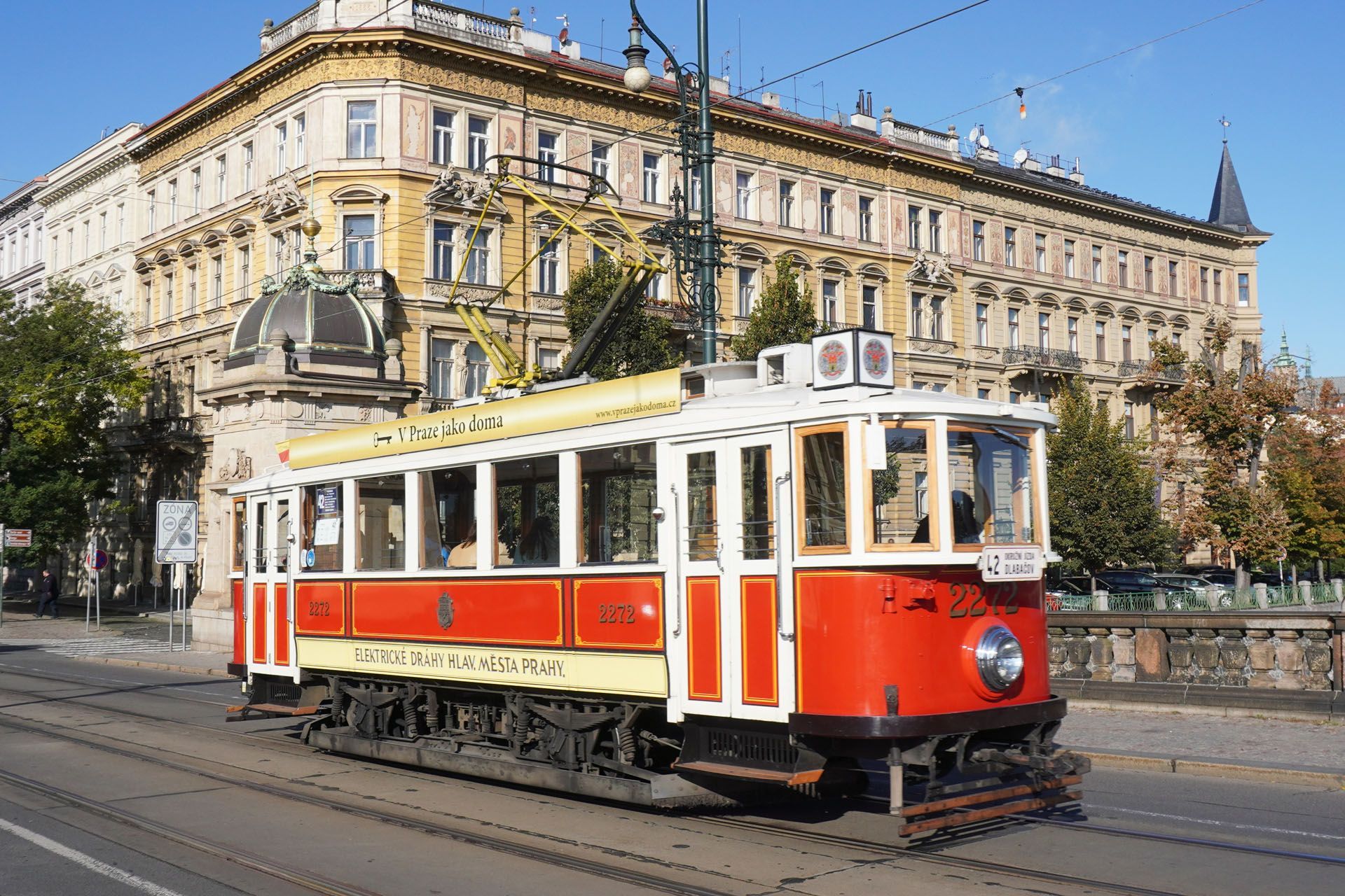 Vintage red and cream tram on tracks in front of an ornate building. Prague, Czech Republic.