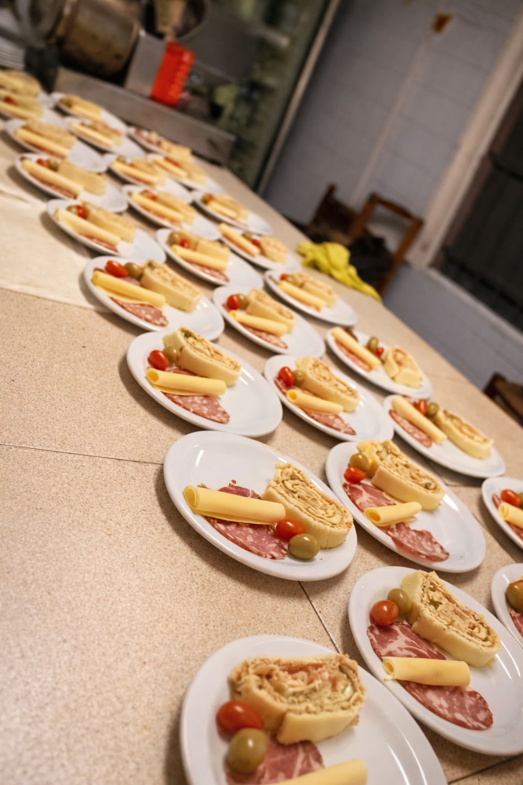 Numerosos platos dispuestos sobre un mostrador, cada uno con un pastel salado enrollado