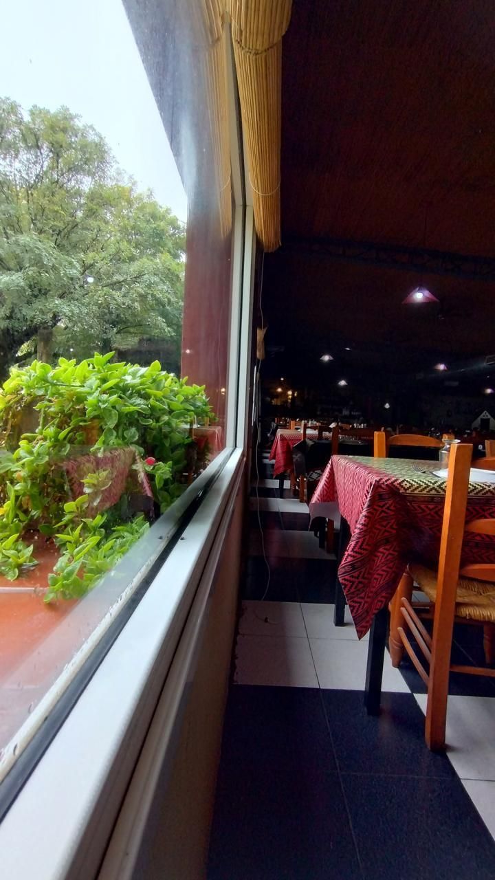 Interior de un restaurante con mesas cubiertas con manteles de cuadros rojos, un suelo de cuadros