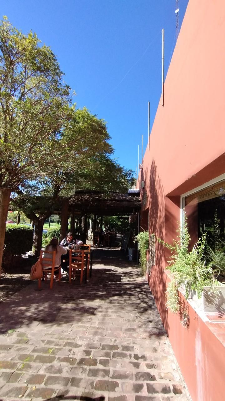 Un sendero de piedra bañado por el sol, que bordea un edificio 