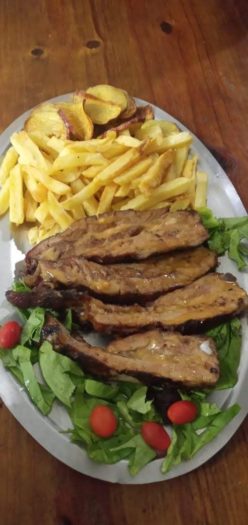 Un plato de carne cocida en rodajas, servido con patatas fritas y una ensalada verde fresca