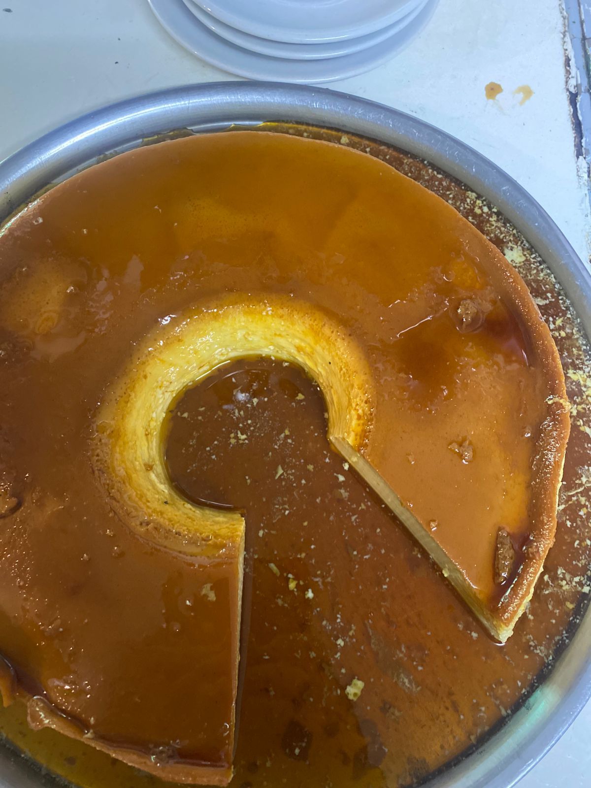 Un postre de natillas en forma de anillo, cubierto con salsa de caramelo