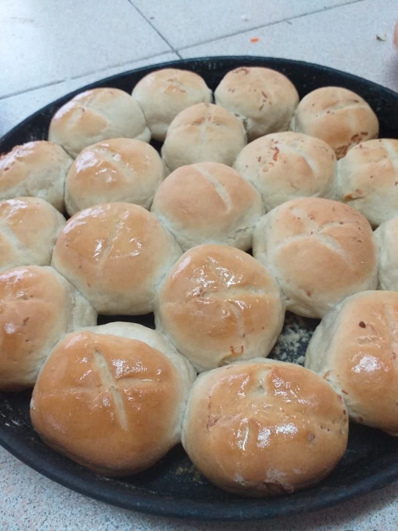 Una bandeja redonda para hornear llena de panecillos frescos y dorados