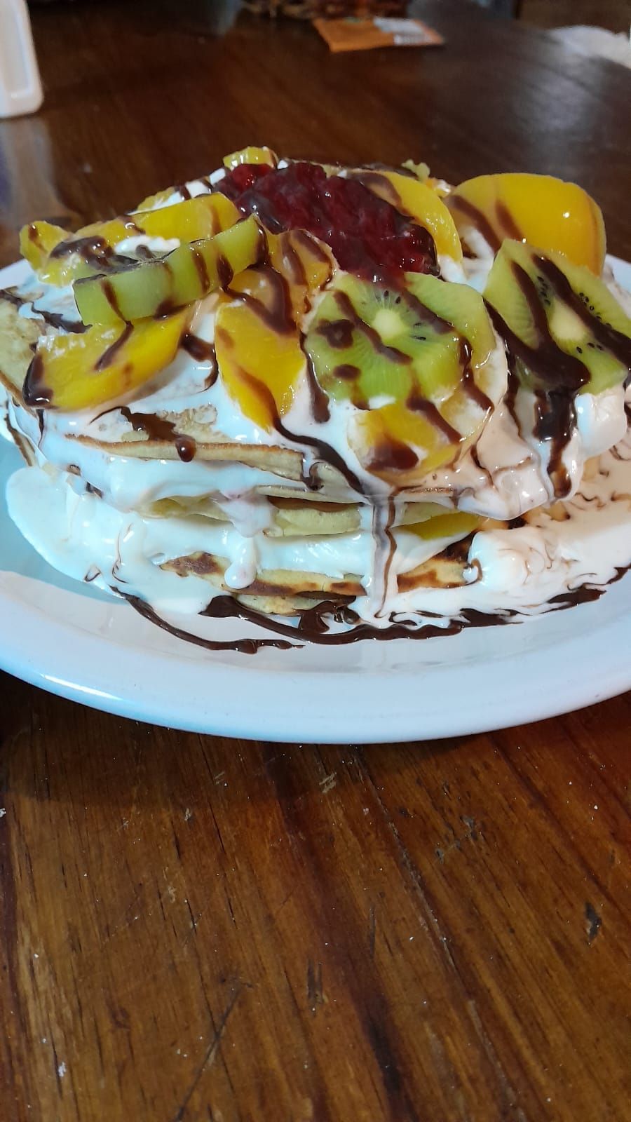 Una pila de panqueques cubiertos con crema batida