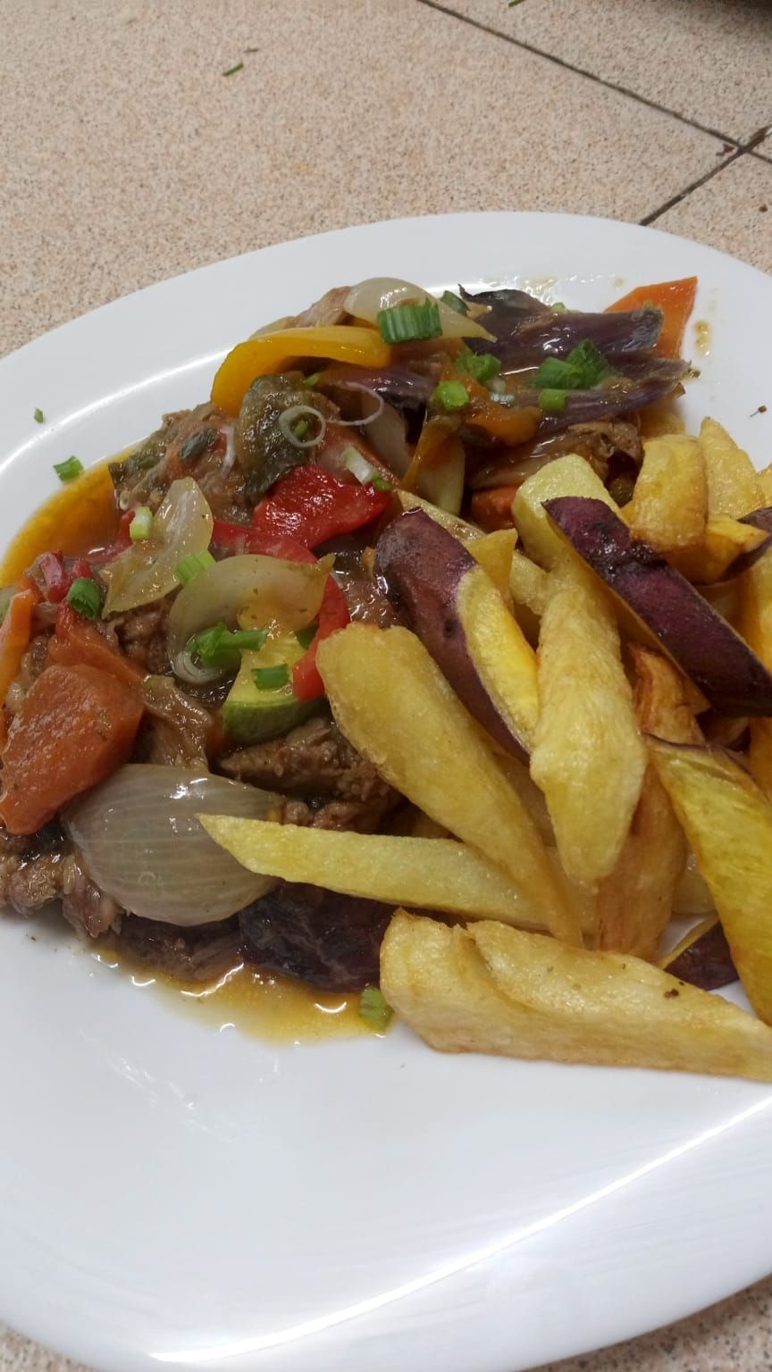 Un plato de lomo saltado, que consiste en carne de res salteada con cebolla, tomate y pimientos