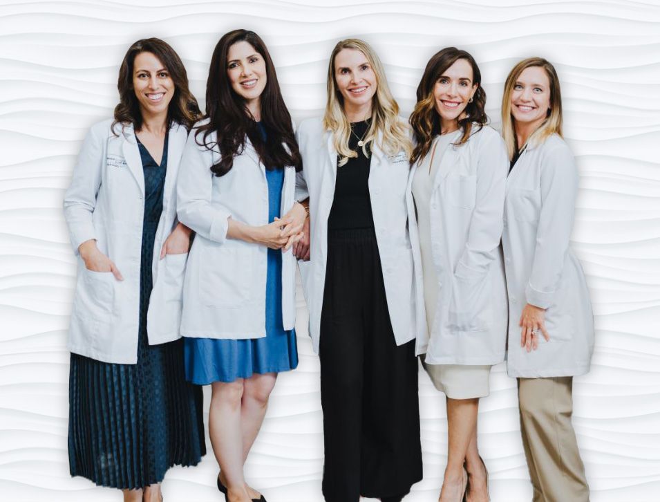 a group of women in white coats are posing for a picture