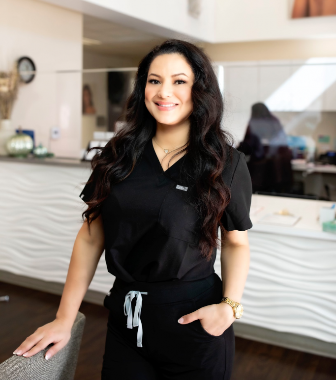 a portrait of Mercedes Alvarez, Esthetician wearing black scrubs