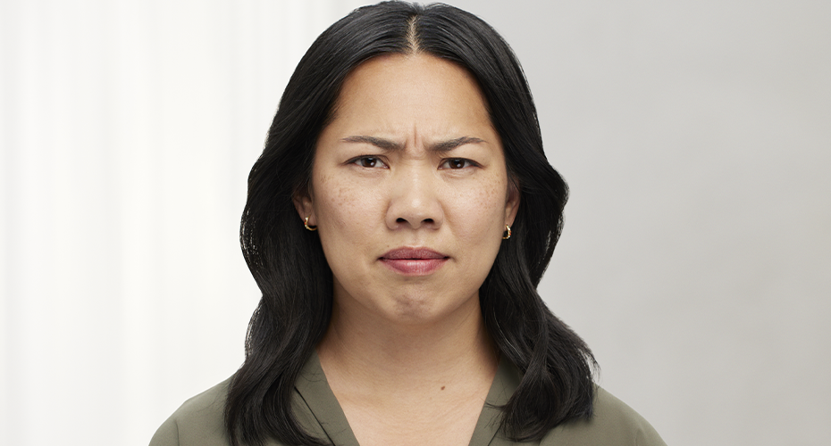 a woman wearing a green shirt is frowning before Botox treatment