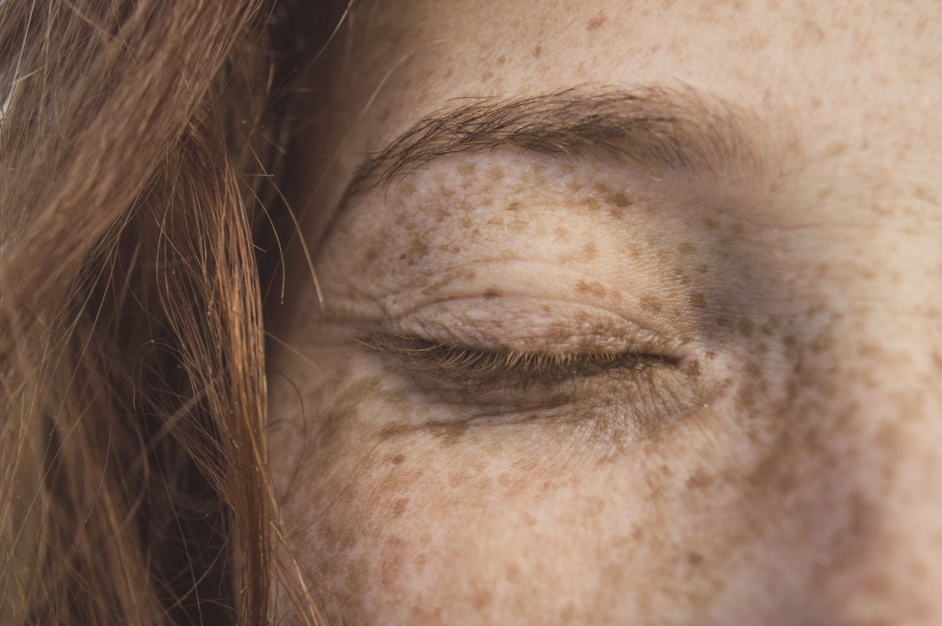 closeup of freckled woman's closed eye