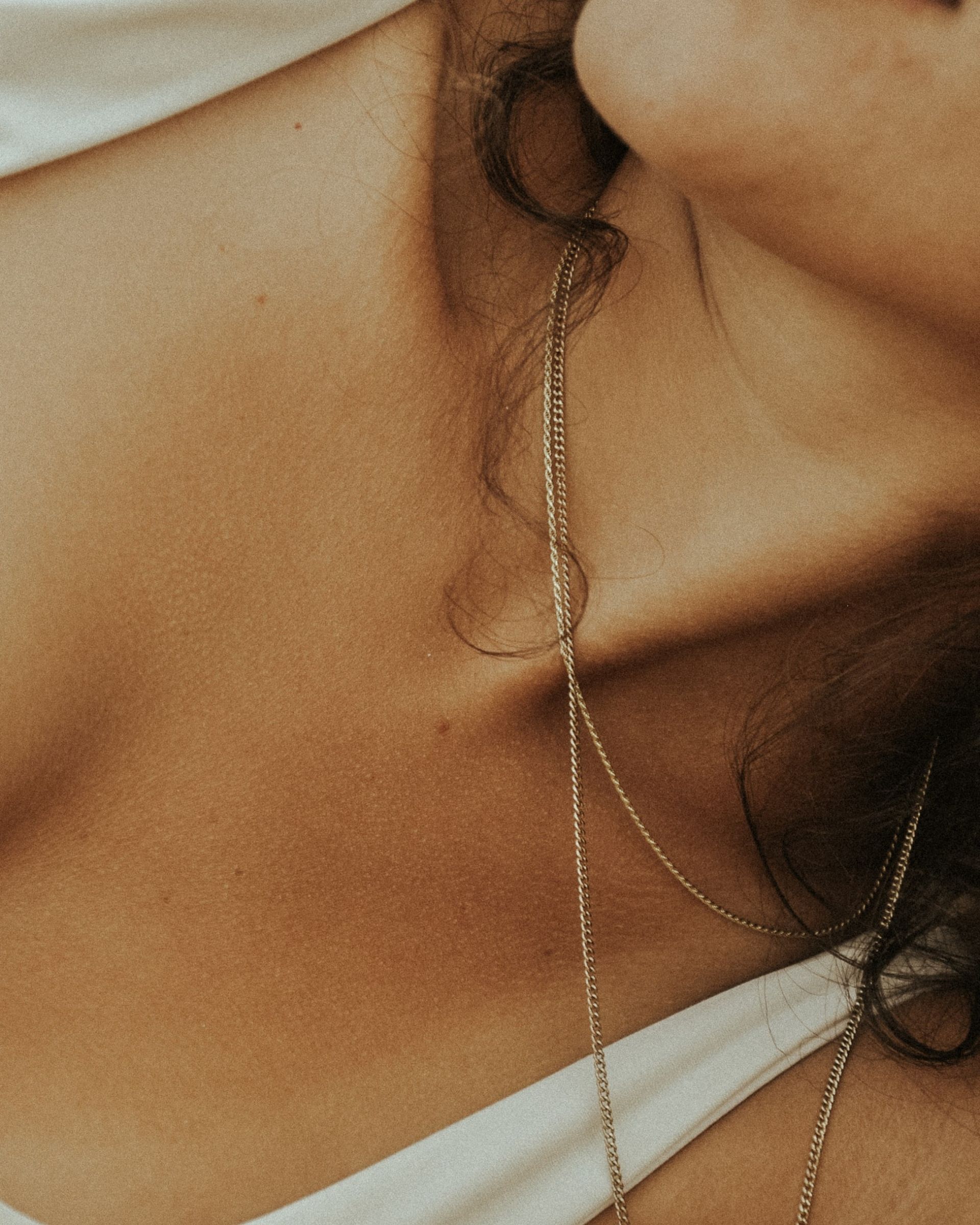 closeup of woman's collarbone with gold necklace