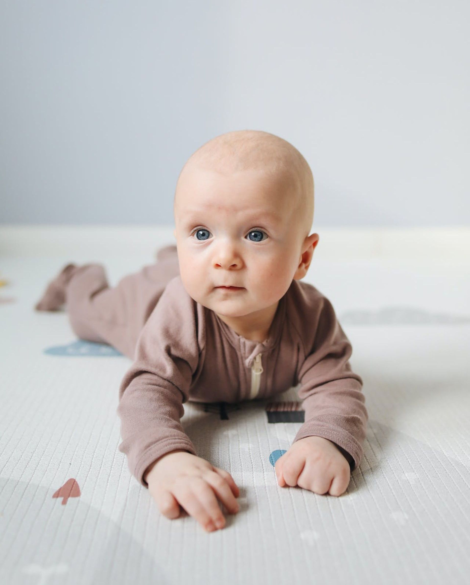 cute baby wearing brown onesie crawling