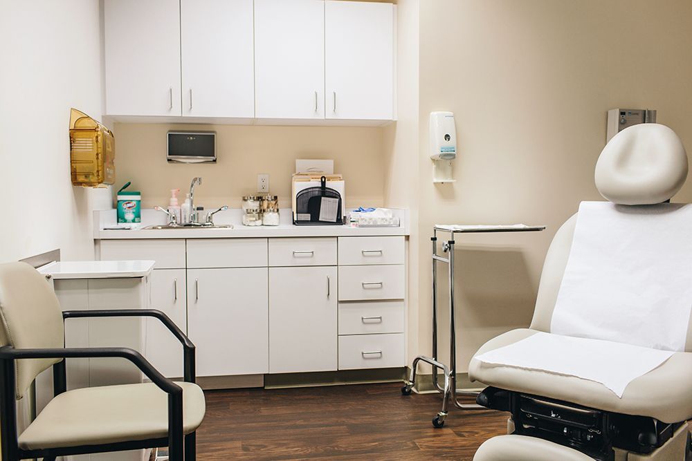 a doctor 's office with a chair and a sink