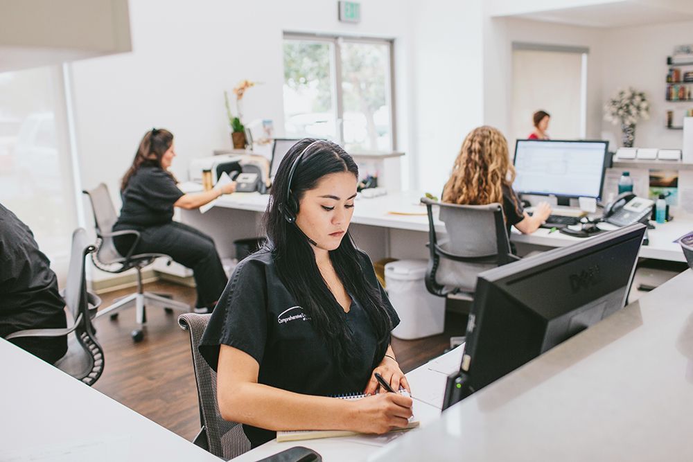 a woman wearing a headset is sitting at a desk in front of a computer .