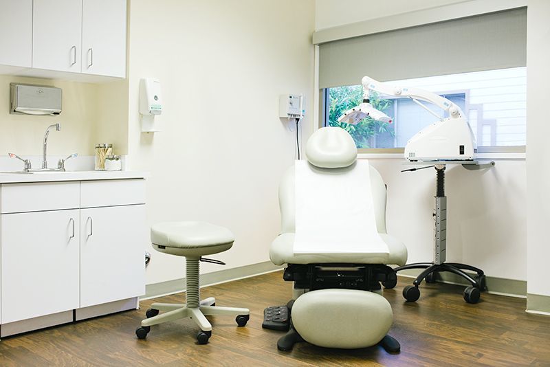 a dental office with a dental chair and stool