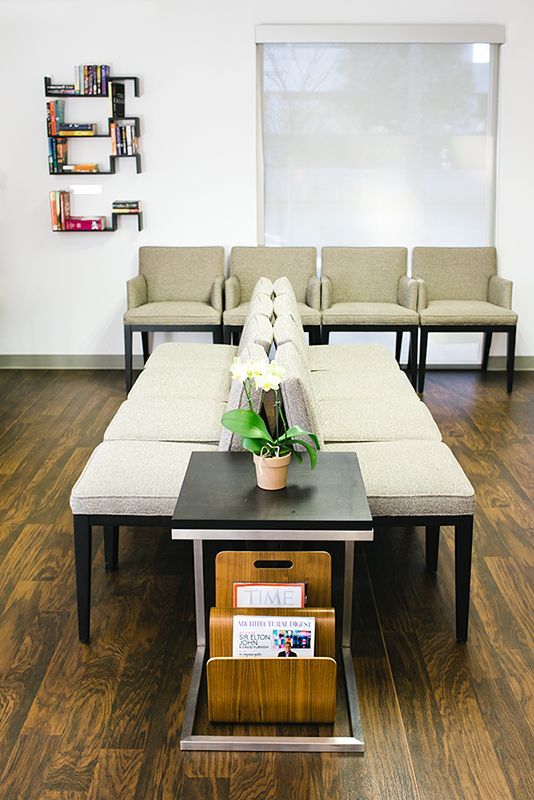 a waiting room with a table and chairs and a potted plant on the table