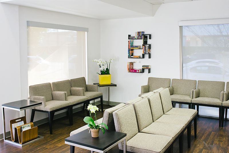 a waiting room with a couch , chairs , and tables