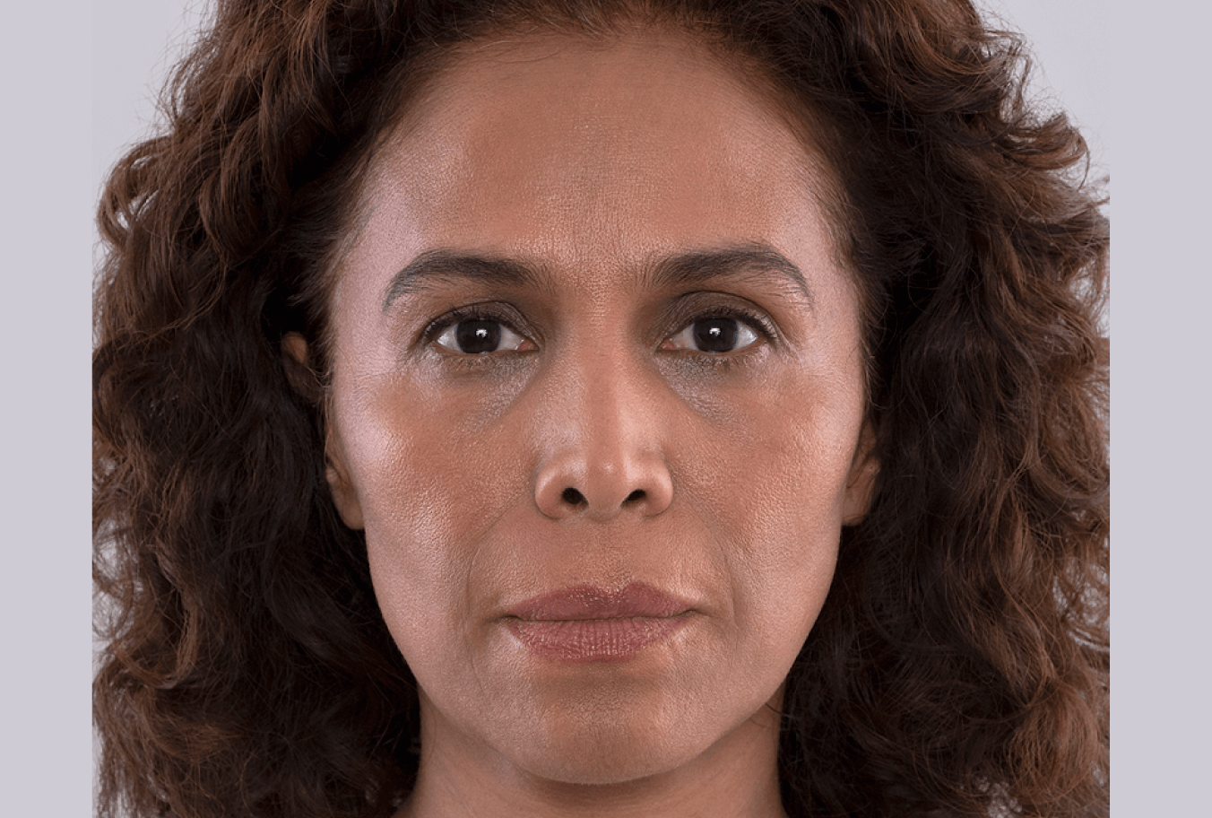 a woman with curly hair is looking at the camera with a serious look on her face