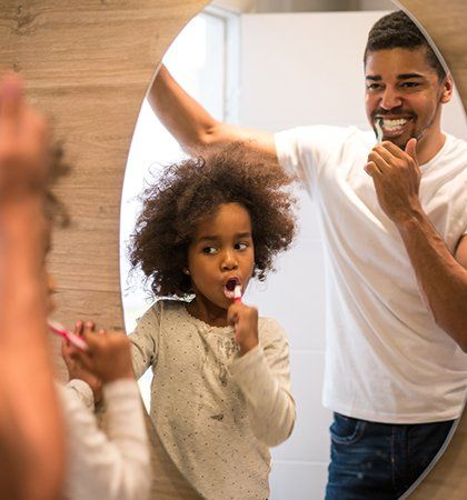 Family Dentistry — Father and Daughter Brushing Teeth Together in Charlotte, NC