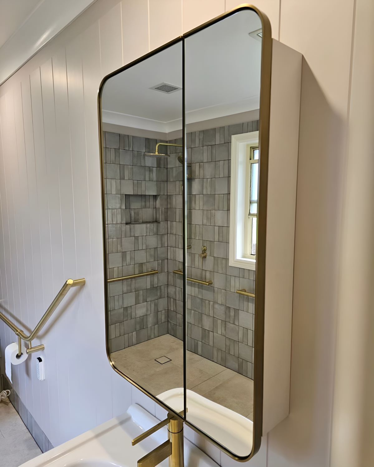 A Bathroom With a Mirror on the Wall and a Sink — Prime Built Group in Bowral, NSW