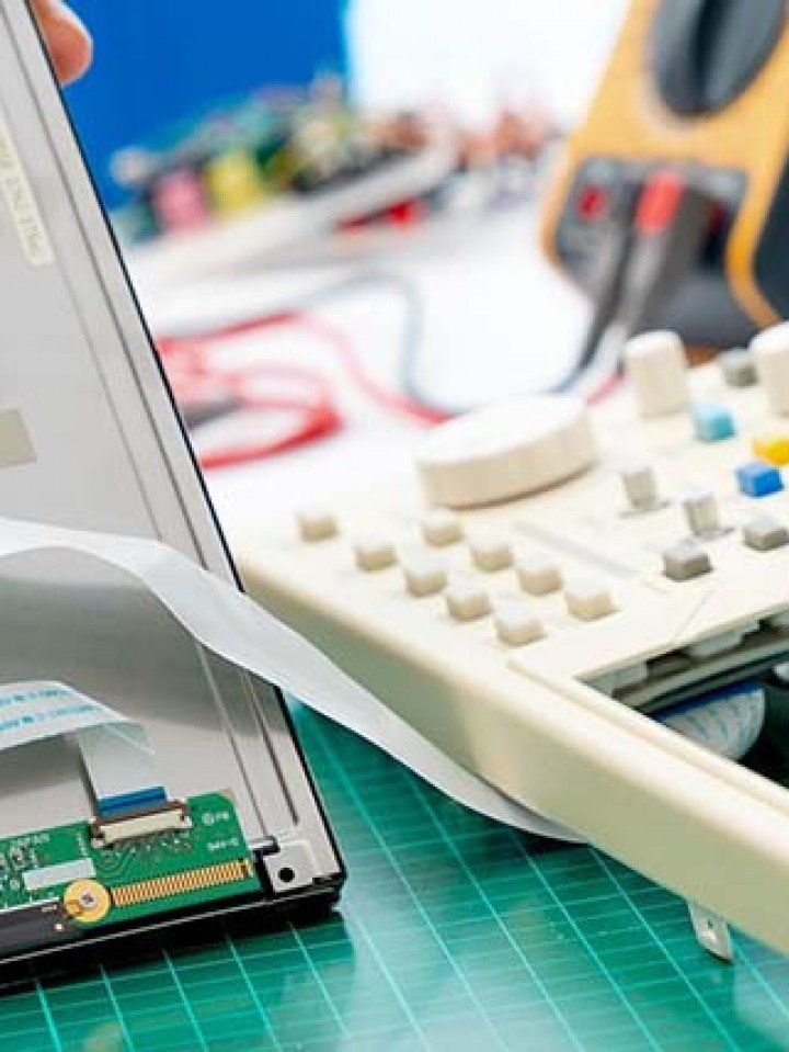 A person is working on a laptop computer on a green cutting board.