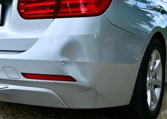 white car with damaged bumper
