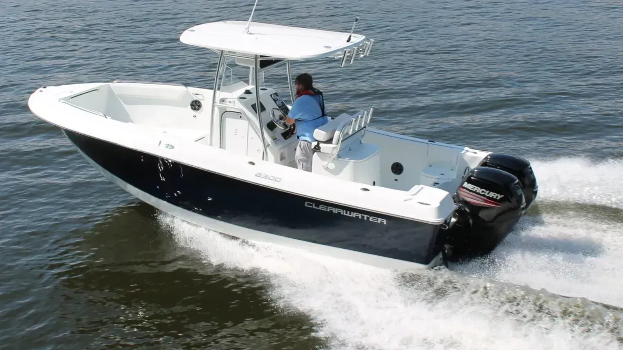 A white and black boat is floating on top of a body of water.