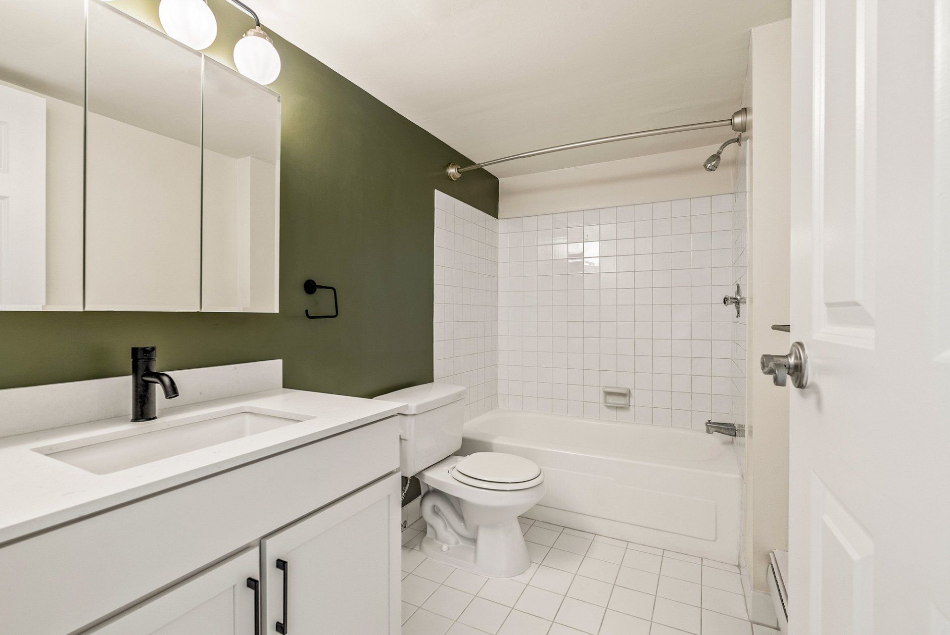A bathroom with a sink , toilet , bathtub and mirror.