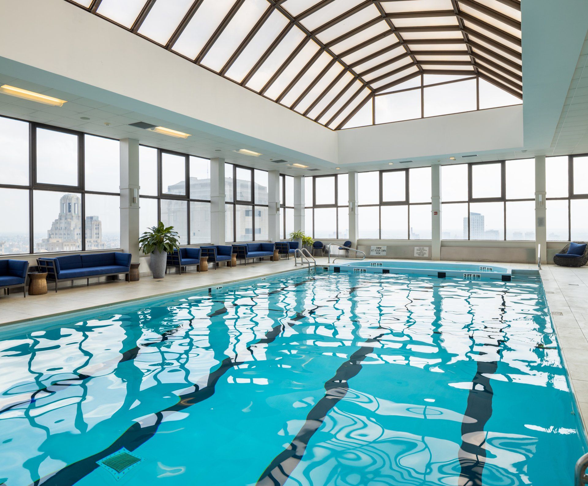 A large indoor swimming pool with a glass roof