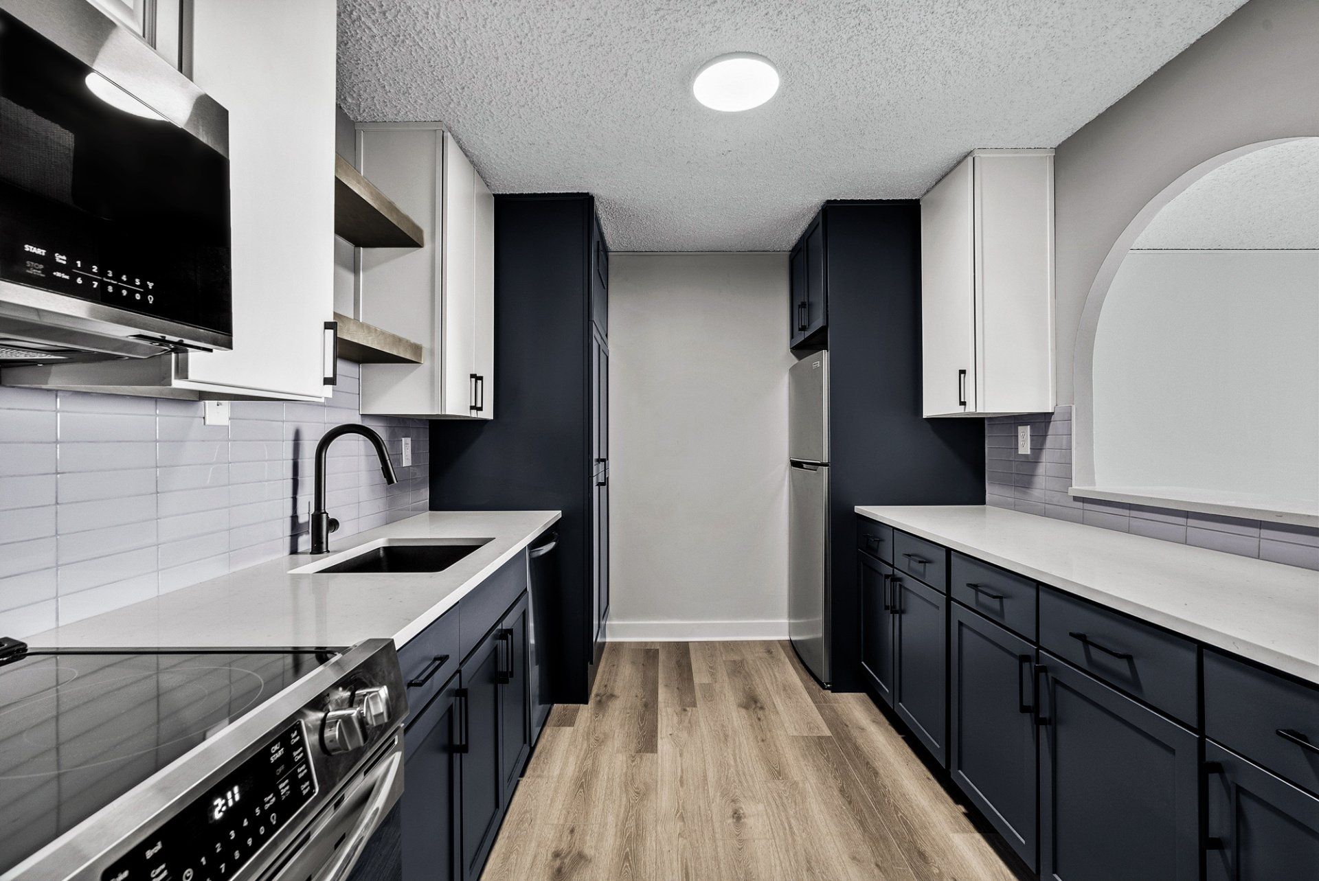 A kitchen with stainless steel appliances and blue cabinets
