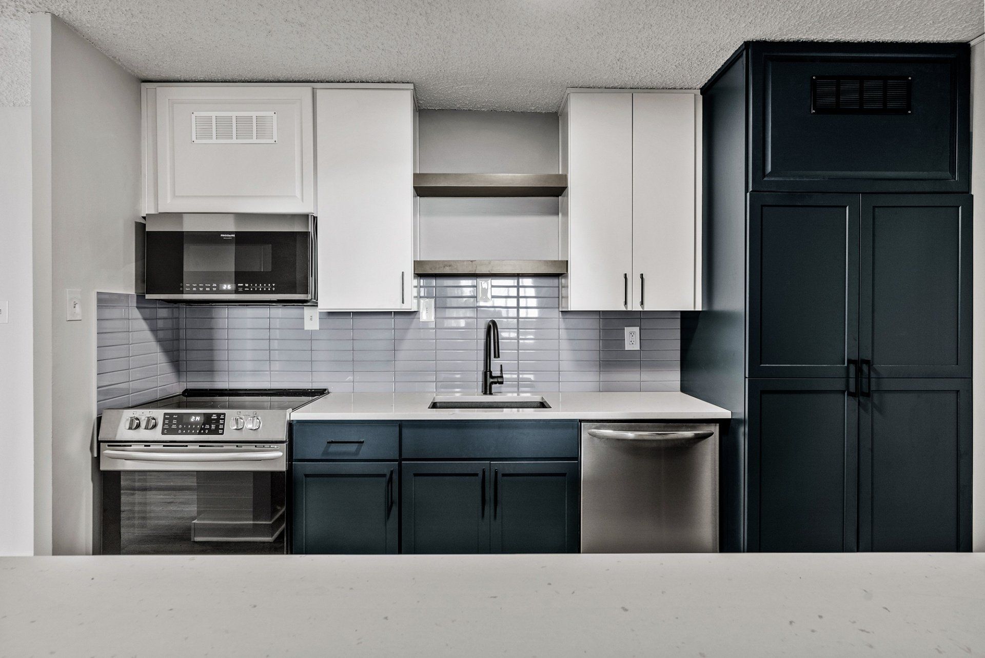 A kitchen with stainless steel appliances and blue cabinets
