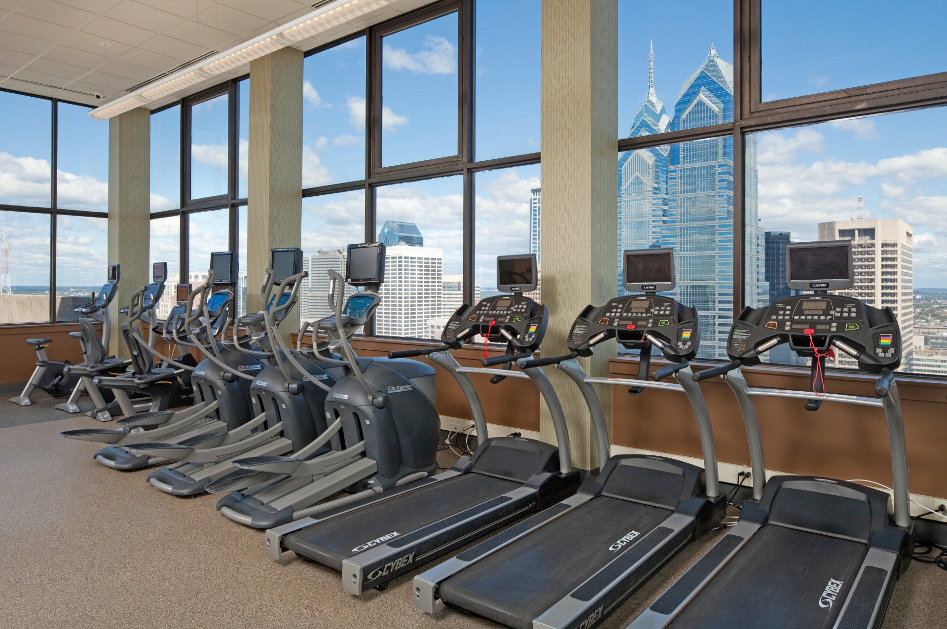 A gym with a lot of treadmills and ellipticals