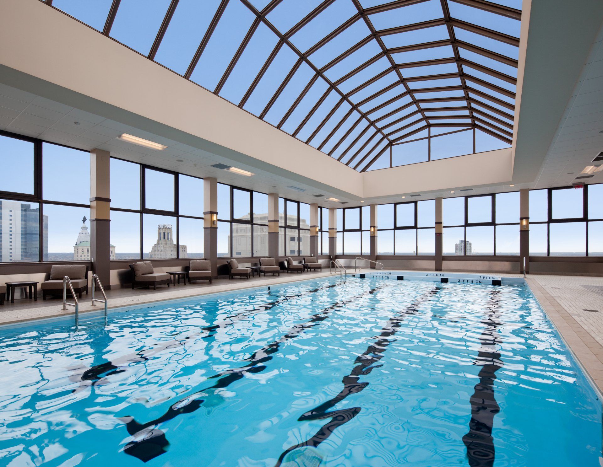 A large indoor swimming pool with a glass roof