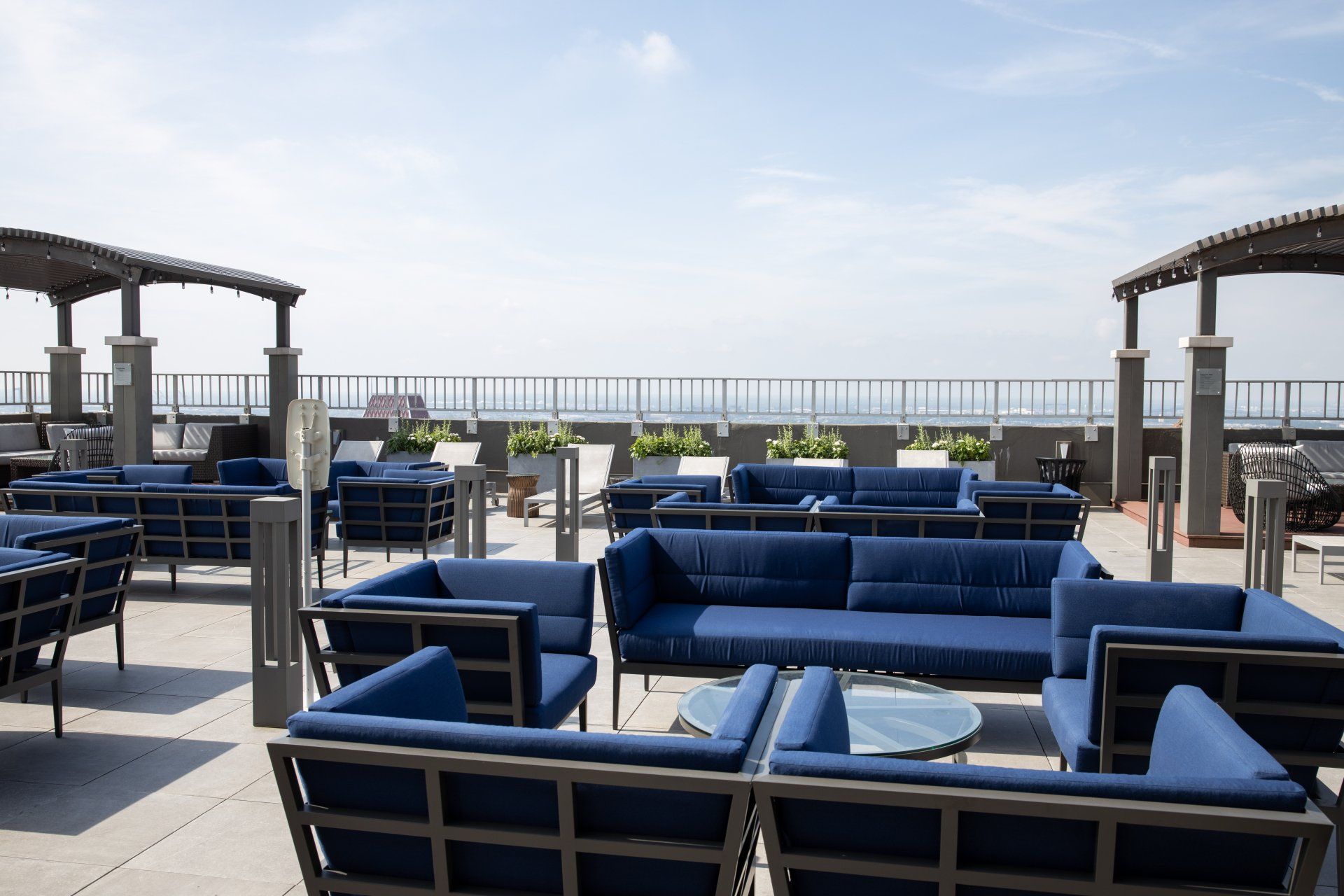 There are many blue couches and chairs on the patio.