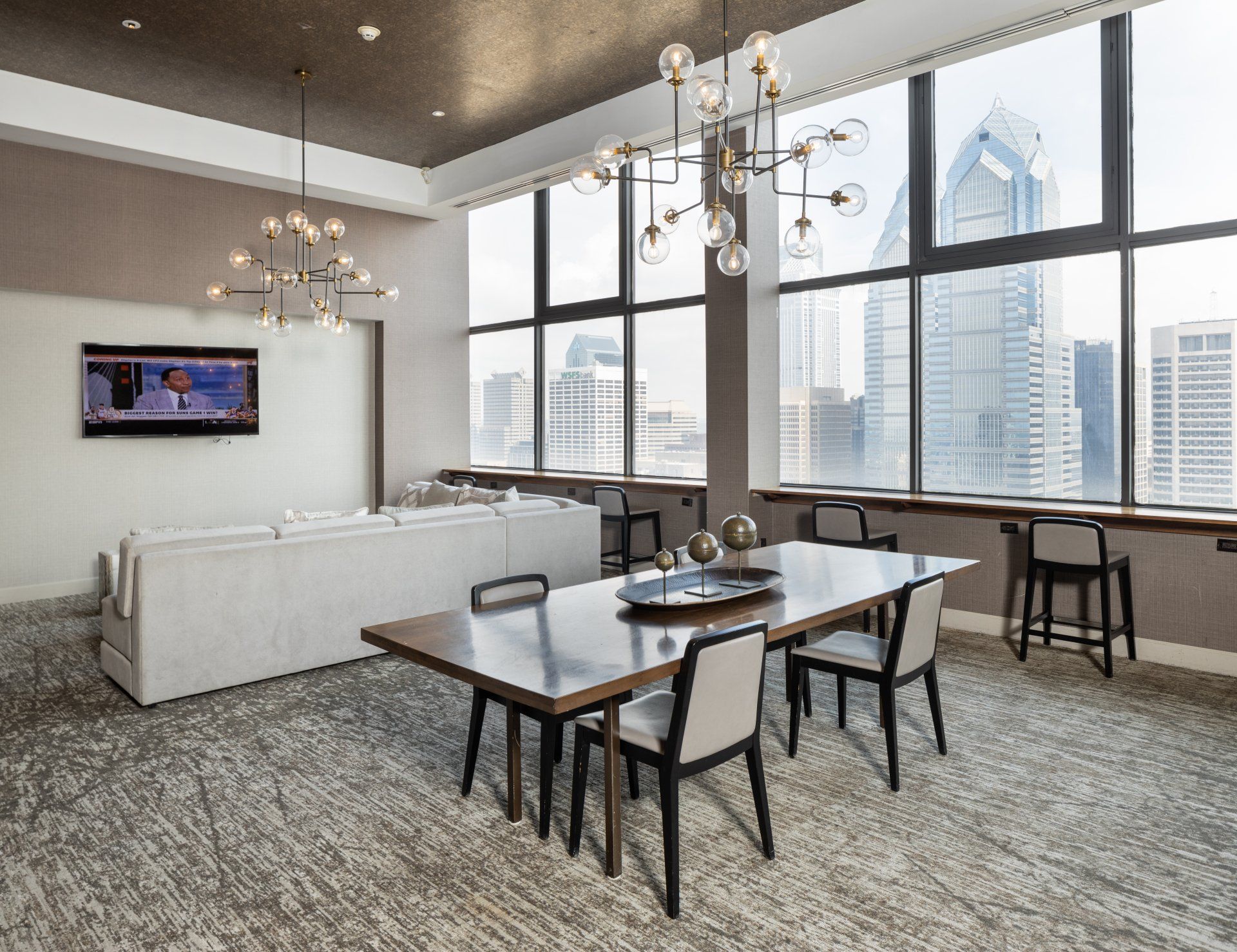 A living room with a table and chairs and a large window.
