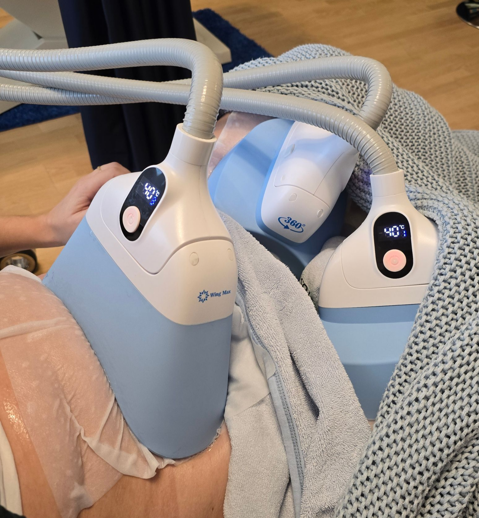 Eine Frau liegt mit einem Gerät am Bein auf einem Bett